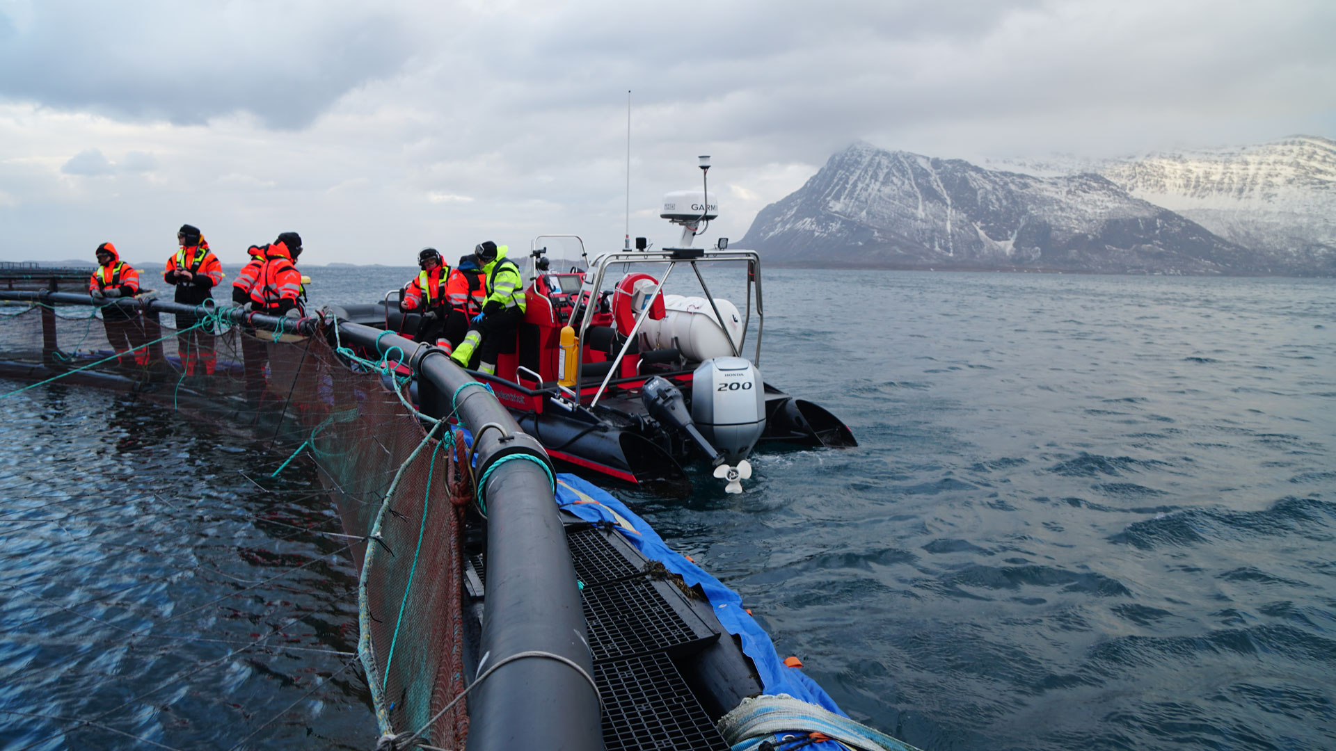 motorboat with people at sea with mountains in background