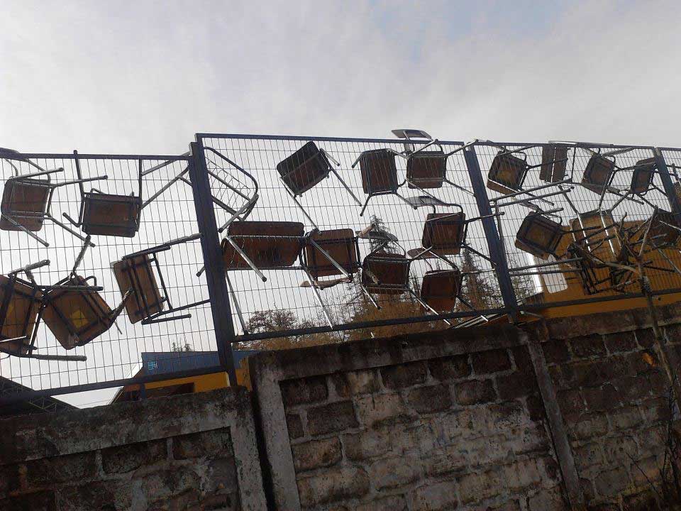 School chairs hanging on a fence
