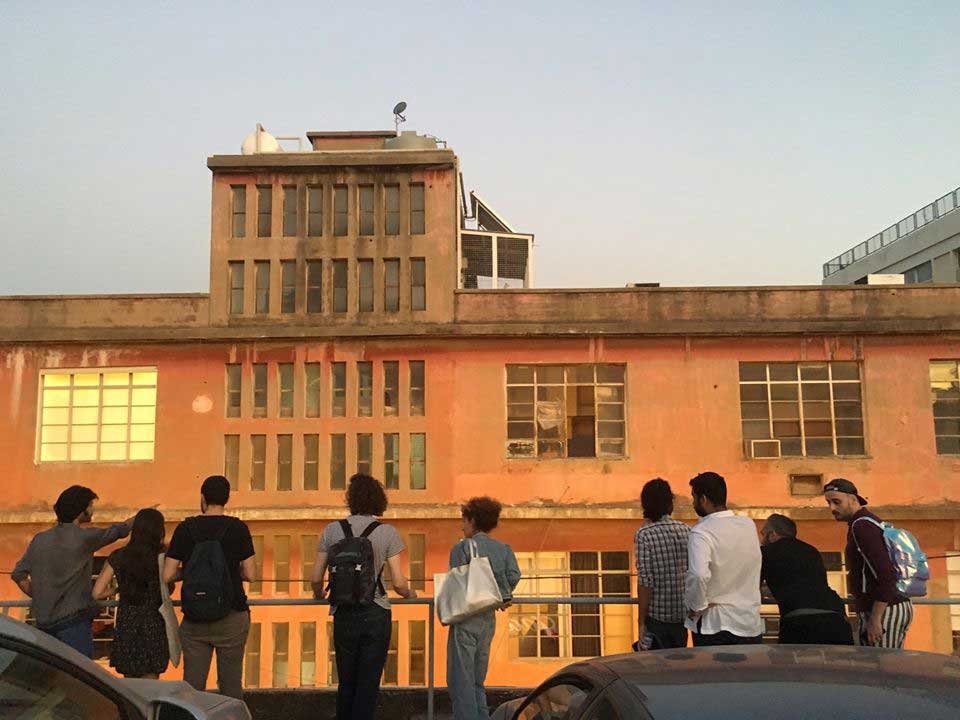 Young people standing outside an industrial building