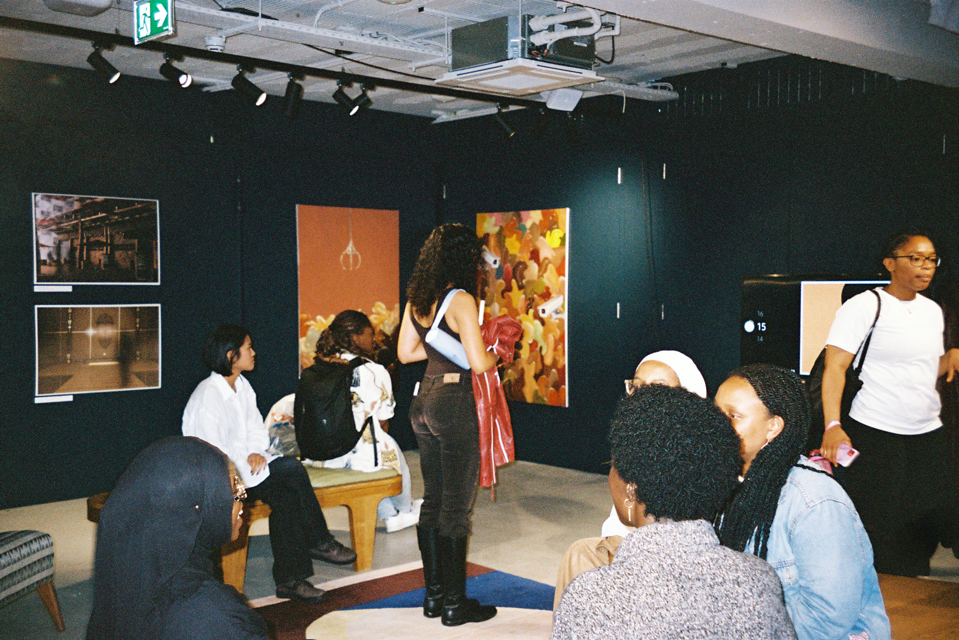 Group of young people, sitting and standing together in an art gallery 