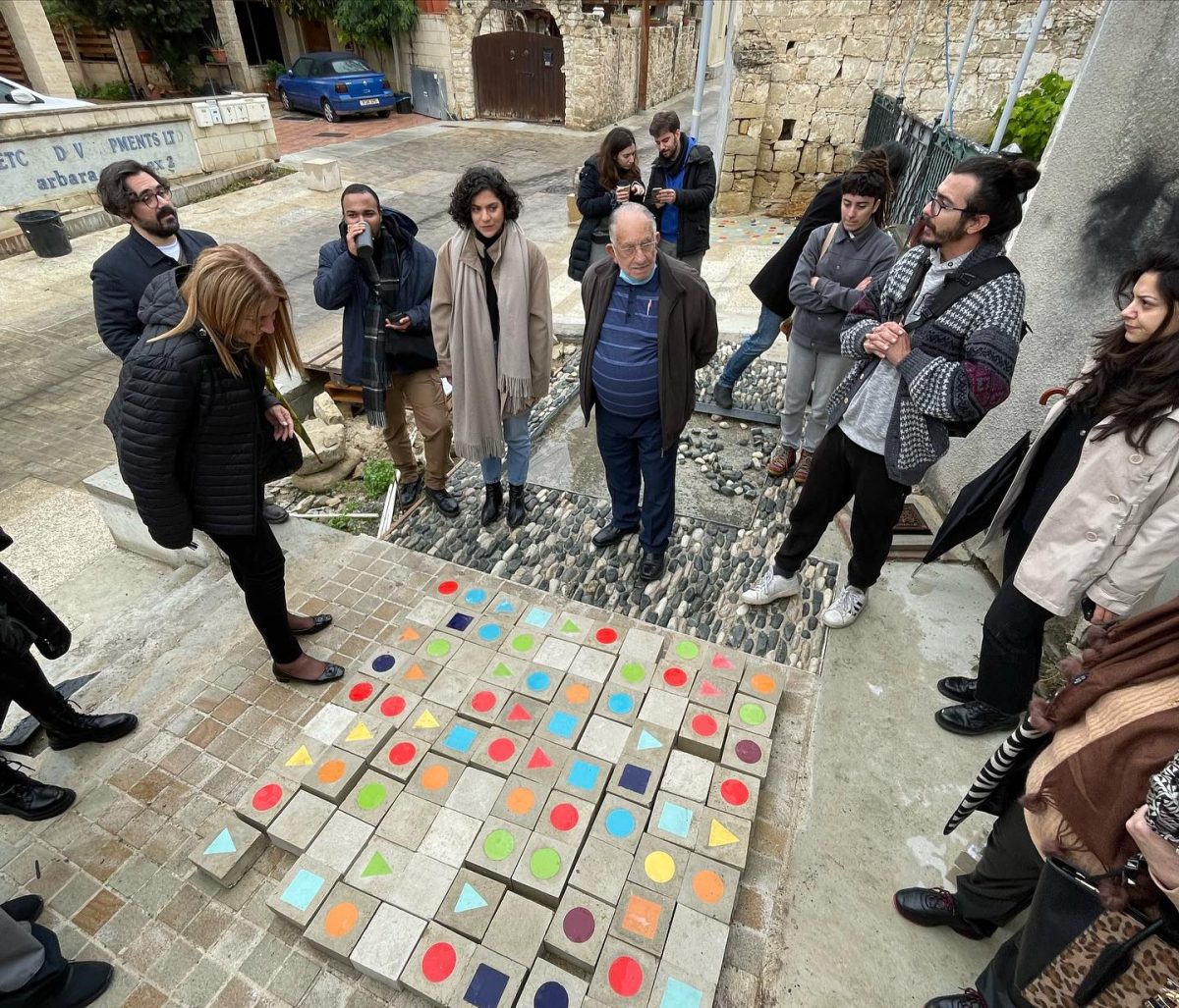 People standing around small building in landscape